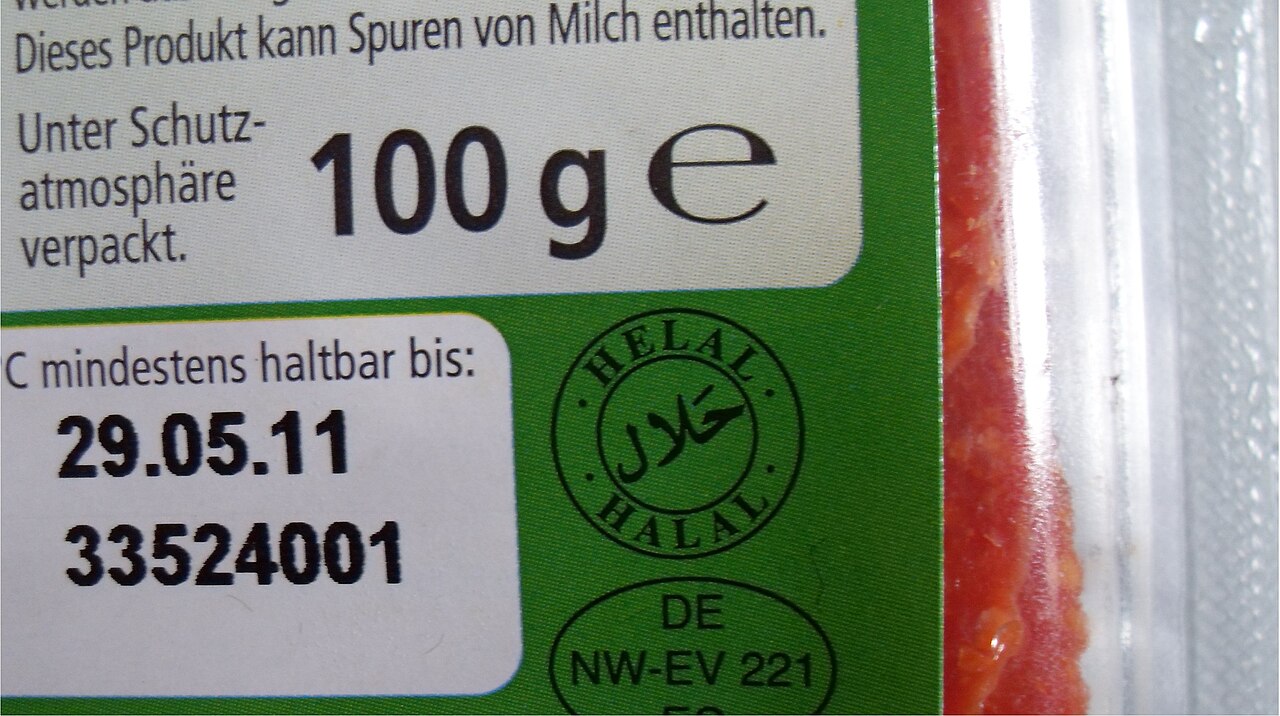 Close-up of a packaged food label carrying a round green halal certification seal with Arabic script